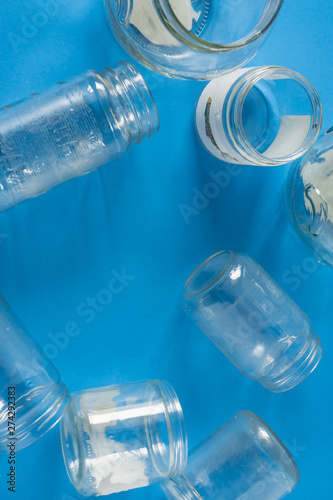 Isolated glass jars without lids flat on blue background with room for copyspace
