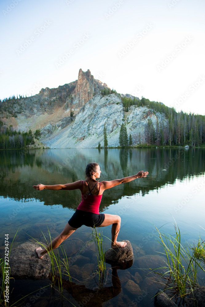 A woman loosens up with an improptu yoga session at Hatchett Lake afer a long day of backpacking in the White Cloud Mountains in Idaho. A woman loosens up with an improptu yoga session at Hatchett Lake afer a long day of backpacking in the White Cloud Mountains in Idaho.