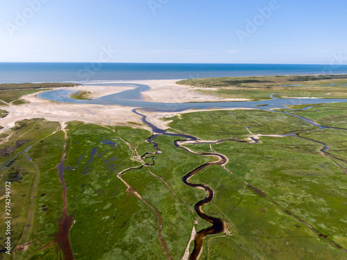 Aerial image of dutch national park with curving rivers in grass land towards the north sea on the island of Texel
