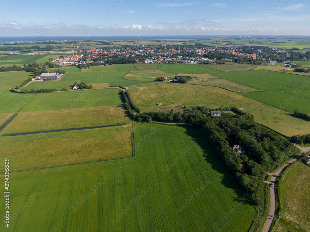 Aerial of meadowland with curving road and farms on the dutch island of Texel