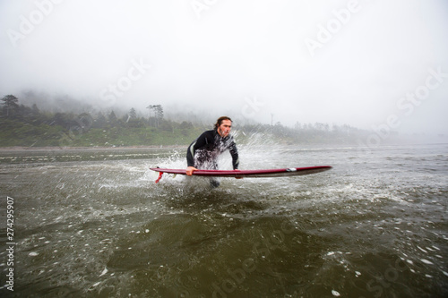 A male surfer  plunges into the surf at a  beach near Kalaloch campground in the Olympic National Park in Washington State. photo