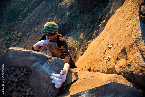 A man clips the anchors after finishing Burning Spears. a 5.10c trad route at Vantage.