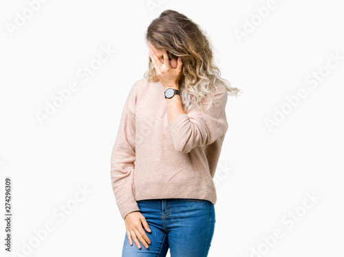 Beautiful young blonde woman wearing sweatershirt over isolated background with sad expression covering face with hands while crying. Depression concept. photo