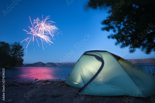 A tent glows my lamp light as nearby campers set of fireworks in celebration of the fourth of July at Banks Lake in central Washington.