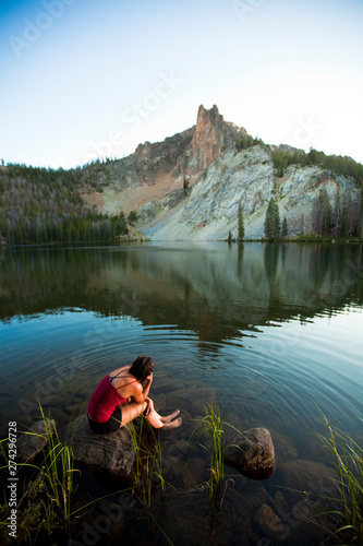 A woman soaks up the alpine bliss while sitting at Hatchett Lake afer a long day of backpacking in the White Cloud Mountains in Idaho. photo