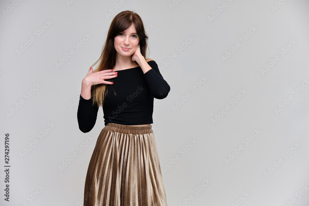 Photo portrait of a beautiful pretty brunette girl in a black sweater on a gray background. A woman is satisfied with her life, she stands in front of the camera, smiling and talking. Made in studio. Photo portrait of a beautiful pretty brunette girl in a black sweater on a gray background. A woman is satisfied with her life, she stands in front of the camera, smiling and talking. Made in studio.