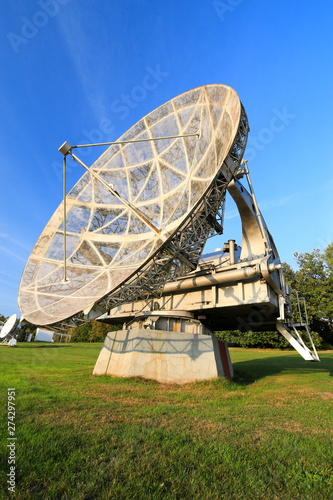 Satellite dish in a summer landscape, sky background.