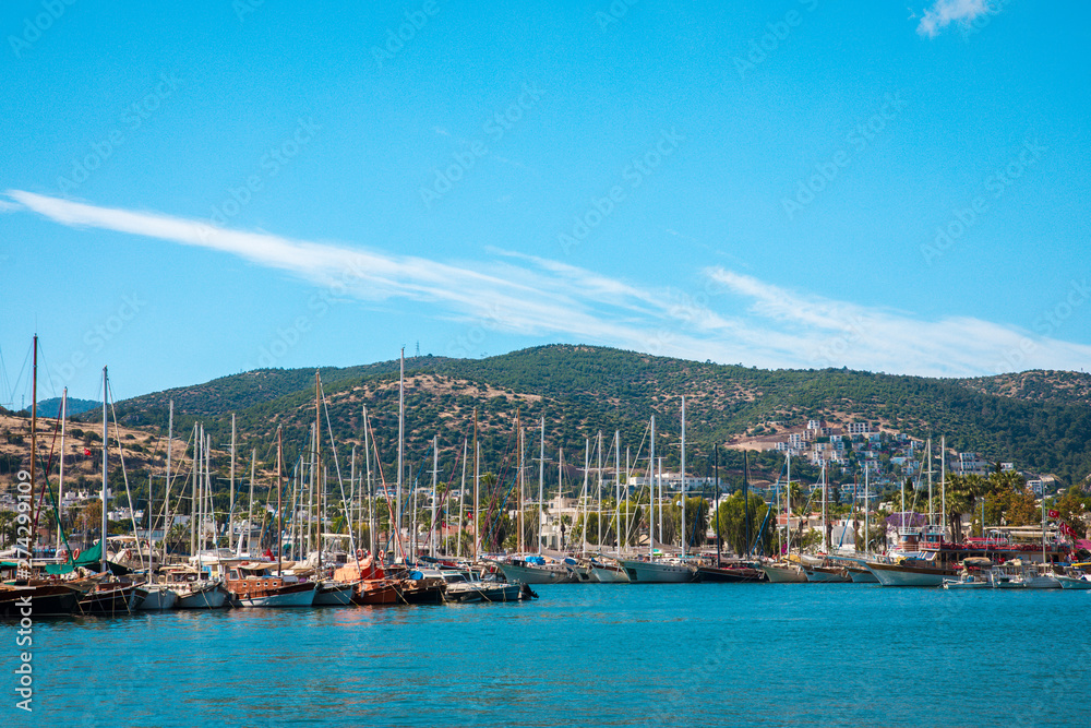 Fototapeta premium View of the Bodrum Marina, sailing boats and yachts in Bodrum town, city of Turkey. Shore and coast of Aegean Sea with yachts