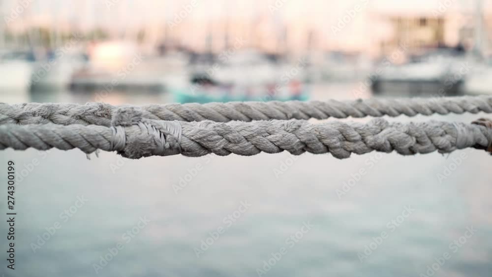 Seaport. Ship ropes. The quay with yachts. White yachts are anchored in the city port on a Sunny day. The port in the city. Flags on yachts in the wind. Boats on the background Seaport. Ship ropes. The quay with yachts. White yachts are anchored in the city port on a Sunny day. The port in the city. Flags on yachts in the wind. Boats on the background