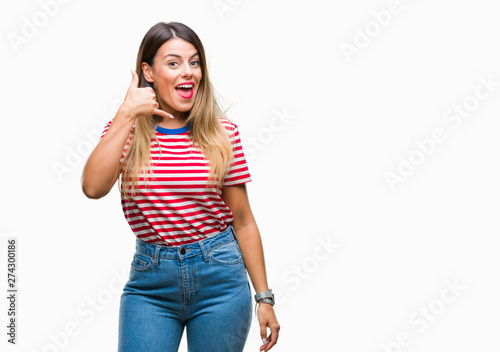 Young beautiful woman casual look over isolated background smiling doing phone gesture with hand and fingers like talking on the telephone. Communicating concepts.