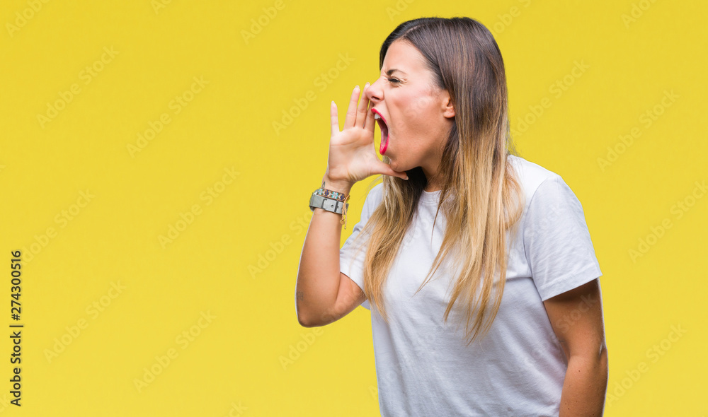 Young beautiful woman casual white t-shirt over isolated background shouting and screaming loud to side with hand on mouth. Communication concept. Young beautiful woman casual white t-shirt over isolated background shouting and screaming loud to side with hand on mouth. Communication concept.