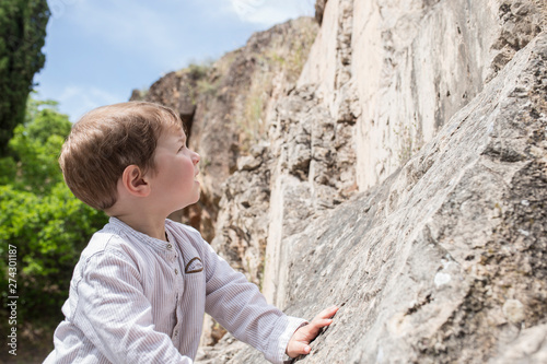 3 years old child boy climbing rock photo