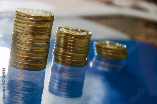 Coins are arranged in ascending order. blue background, reflecting. Close-up. photo