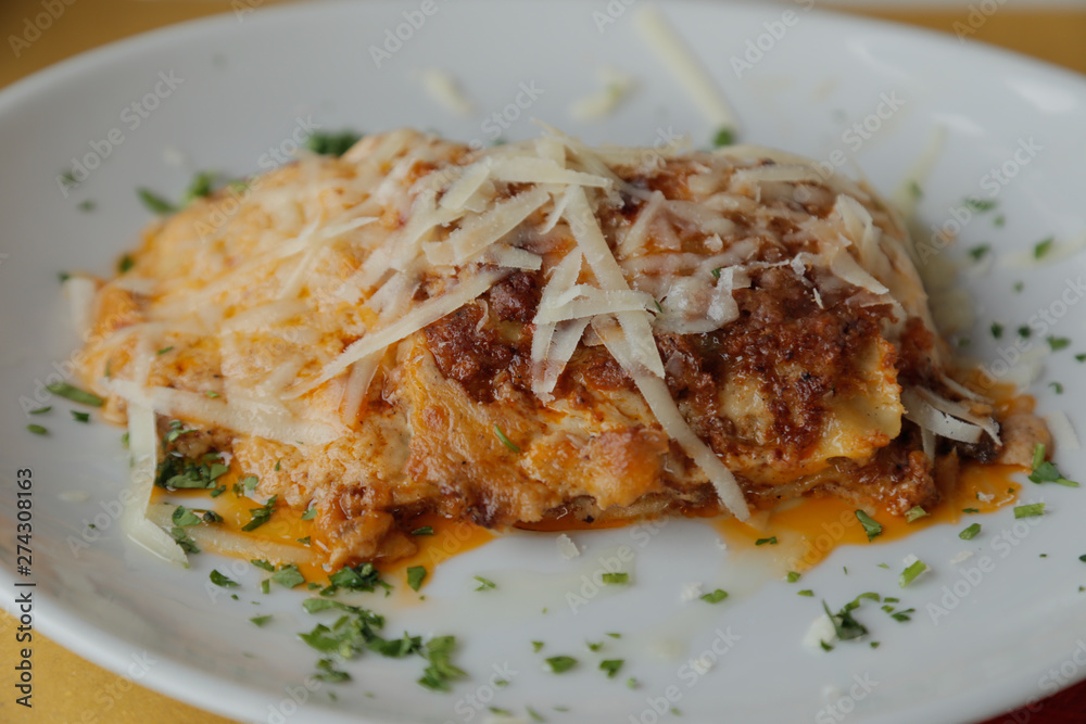delicious lasagna with meat and grated parmesan served on a white dish delicious lasagna with meat and grated parmesan served on a white dish