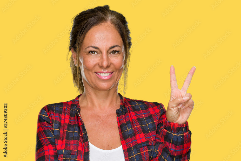 Middle age adult woman wearing casual jacket over isolated background smiling with happy face winking at the camera doing victory sign. Number two. Middle age adult woman wearing casual jacket over isolated background smiling with happy face winking at the camera doing victory sign. Number two.