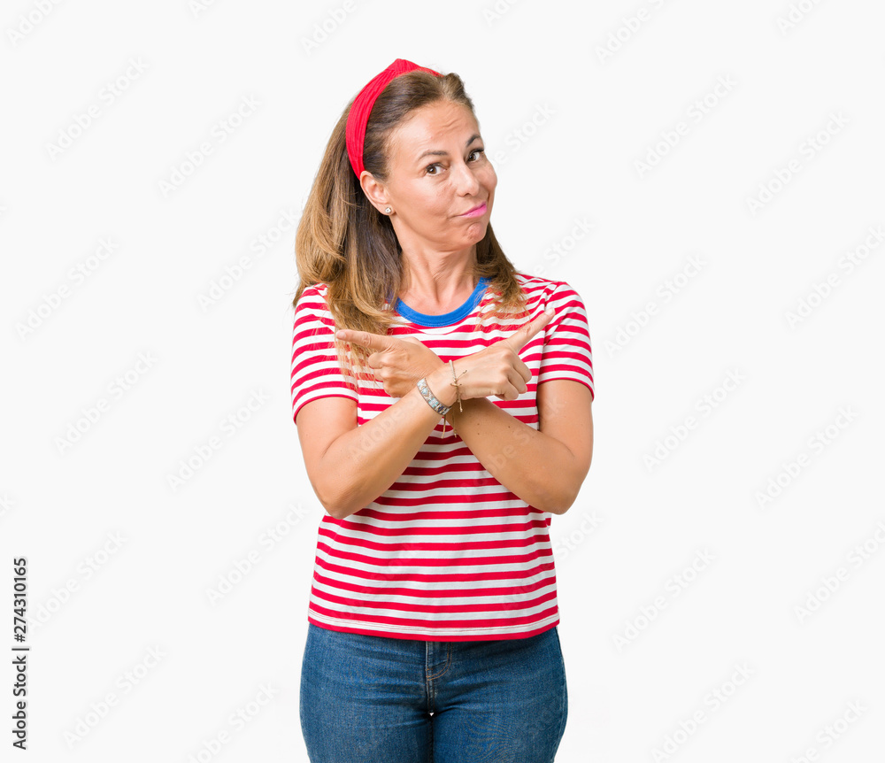 Beautiful middle age woman wearing casual stripes t-shirt over isolated background Pointing to both sides with fingers, different direction disagree Beautiful middle age woman wearing casual stripes t-shirt over isolated background Pointing to both sides with fingers, different direction disagree