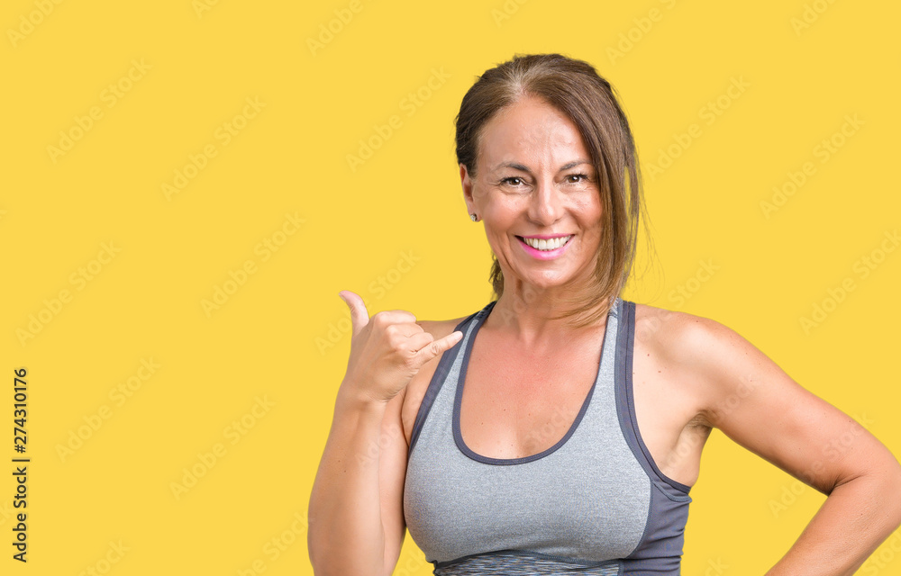Beautiful middle age woman wearing sport clothes over isolated background smiling doing phone gesture with hand and fingers like talking on the telephone. Communicating concepts. Beautiful middle age woman wearing sport clothes over isolated background smiling doing phone gesture with hand and fingers like talking on the telephone. Communicating concepts.