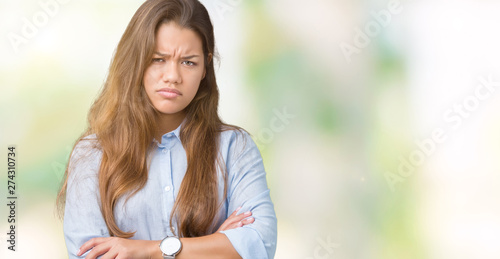 Young beautiful brunette business woman over isolated background skeptic and nervous, disapproving expression on face with crossed arms. Negative person. © Krakenimages.com