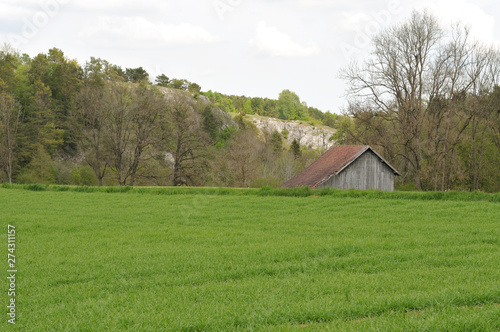 landscape with wooden barn and limestone rocks