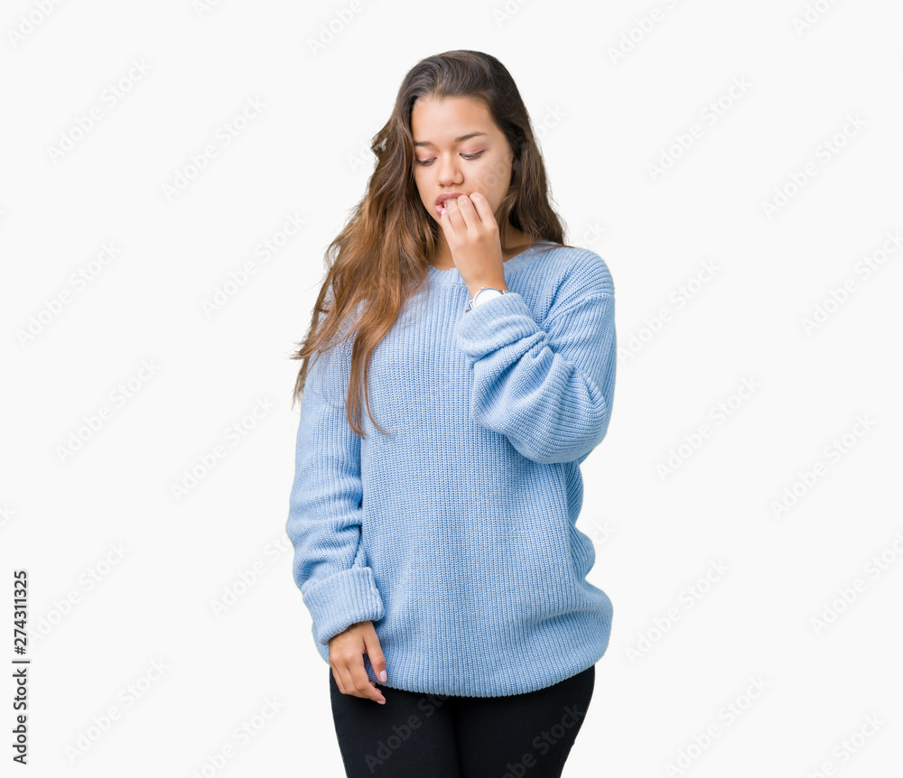 Young beautiful brunette woman wearing blue winter sweater over isolated background looking stressed and nervous with hands on mouth biting nails. Anxiety problem. Young beautiful brunette woman wearing blue winter sweater over isolated background looking stressed and nervous with hands on mouth biting nails. Anxiety problem.
