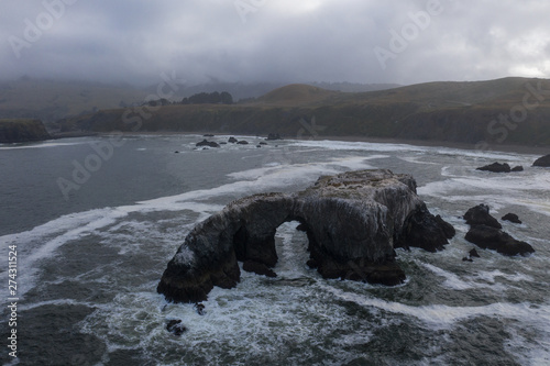 The cold, nutrient-rich waters of the Pacific Ocean wash a natural arch along the scenic coastline of Northern California. This area is easily accessible from the famous California route 1.
