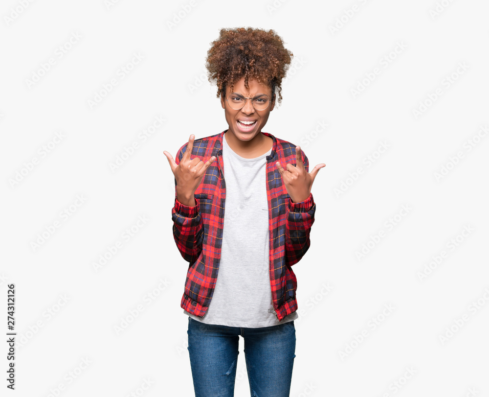 Beautiful young african american woman wearing glasses over isolated background shouting with crazy expression doing rock symbol with hands up. Music star. Heavy concept. Beautiful young african american woman wearing glasses over isolated background shouting with crazy expression doing rock symbol with hands up. Music star. Heavy concept.