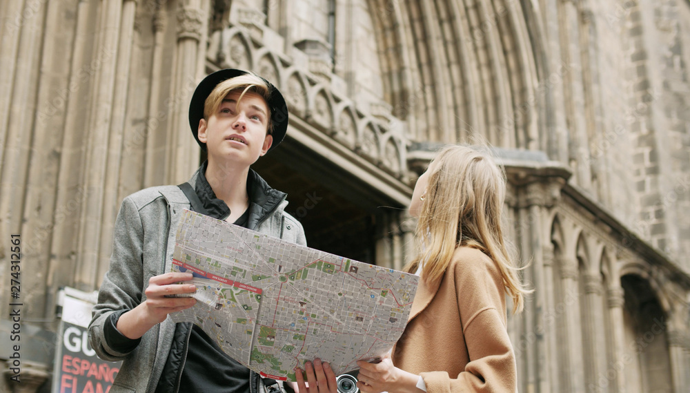 Two stylish friend standing at the street and look for something using a map Two stylish friend standing at the street and look for something using a map