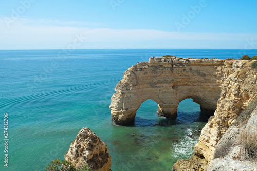 Rocky beaches with cliffs somwhere, somwhere in Algarve, Portugal. Atlantic ocean shore background. Copy space for text.