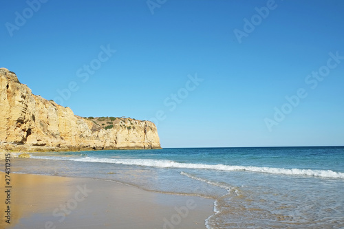 Rocky beaches with cliffs somwhere, somwhere in Algarve, Portugal. Atlantic ocean shore background. Copy space for text.