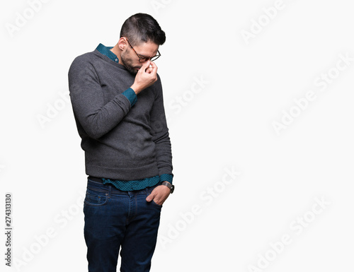 Young handsome man wearing glasses over isolated background tired rubbing nose and eyes feeling fatigue and headache. Stress and frustration concept. © Krakenimages.com