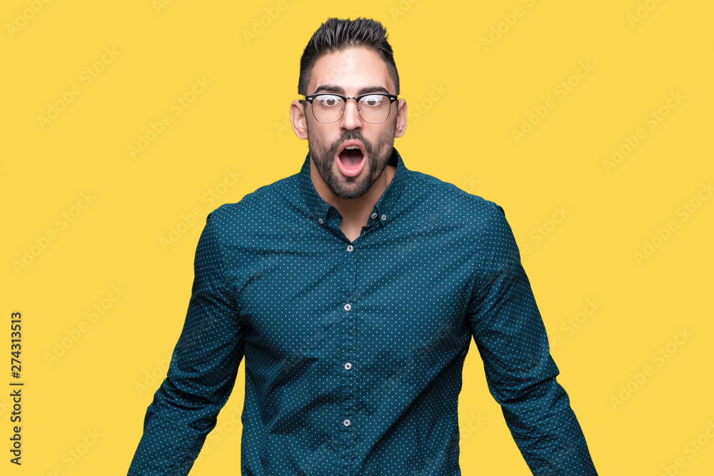 Young handsome business man wearing glasses over isolated background afraid and shocked with surprise expression, fear and excited face. Young handsome business man wearing glasses over isolated background afraid and shocked with surprise expression, fear and excited face.