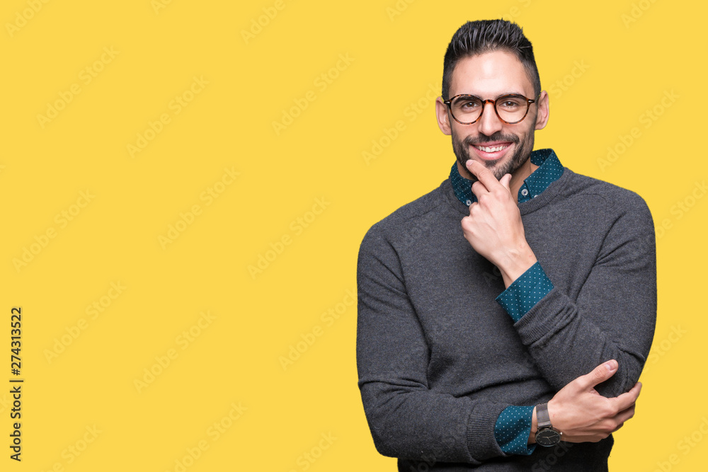 Young handsome man wearing glasses over isolated background looking confident at the camera with smile with crossed arms and hand raised on chin. Thinking positive. Young handsome man wearing glasses over isolated background looking confident at the camera with smile with crossed arms and hand raised on chin. Thinking positive.