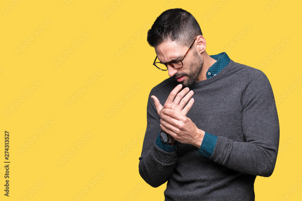 Young handsome man wearing glasses over isolated background Suffering pain on hands and fingers, arthritis inflammation Young handsome man wearing glasses over isolated background Suffering pain on hands and fingers, arthritis inflammation