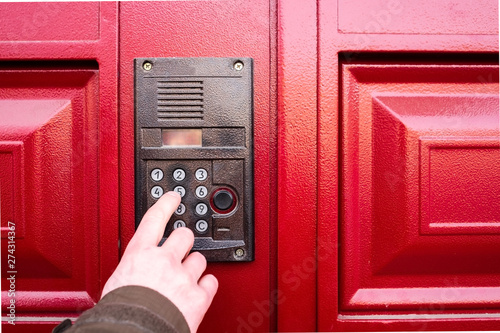 Male hand presses a button on doorbell and intercom. photo