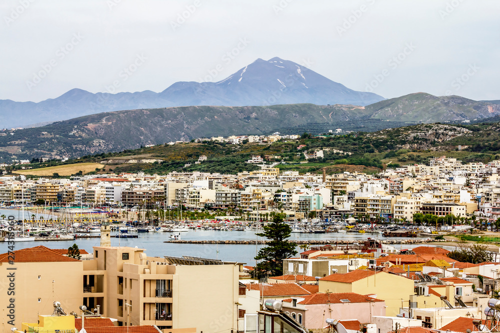 View of the promenade and houses against the mountains in Rethymno in Greece.