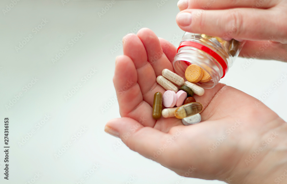Colored pills, vitamins on the palm on a light background. Colored pills, vitamins on the palm on a light background.