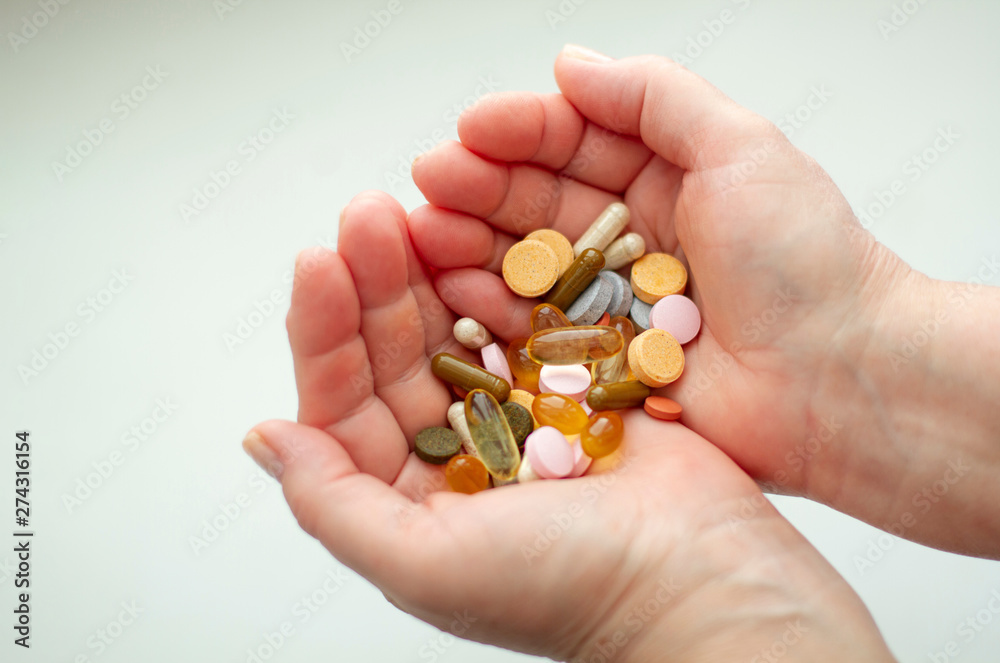 Colored pills, vitamins on the palm on a light background. Colored pills, vitamins on the palm on a light background.