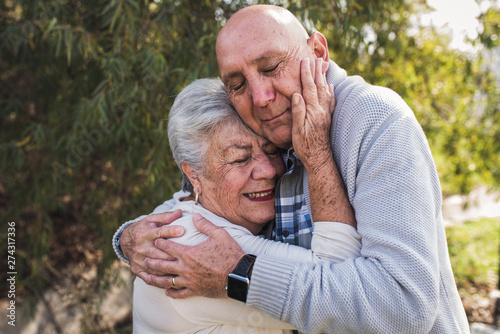 close up portrait of grandfather and his mother embracing outside