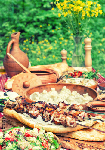 Shashlik khinkali salad Georgian food nature background vintage