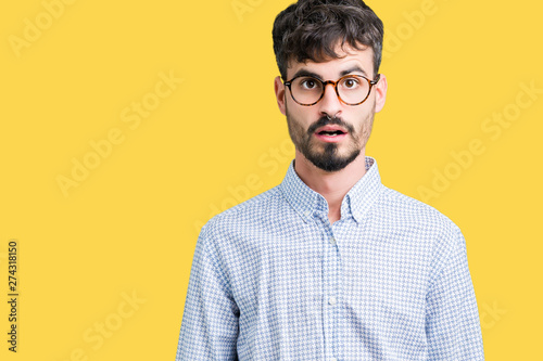 Young handsome man wearing glasses over isolated background afraid and shocked with surprise expression, fear and excited face.