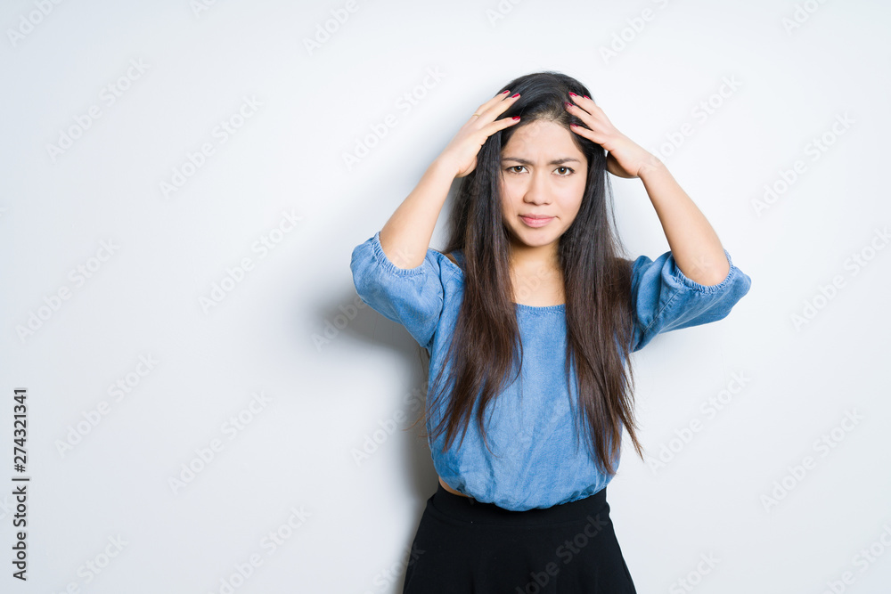 Beautiful brunette woman over isolated background suffering from headache desperate and stressed because pain and migraine. Hands on head. Beautiful brunette woman over isolated background suffering from headache desperate and stressed because pain and migraine. Hands on head.