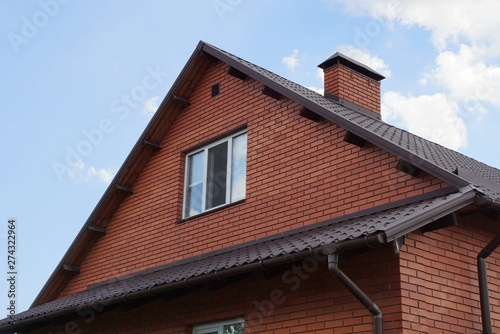 brown loft brick house with a window against the sky