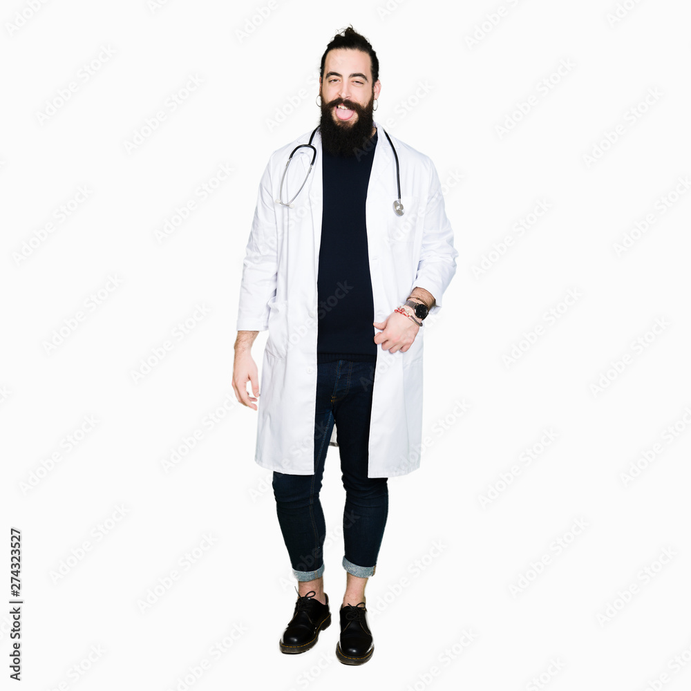 Doctor with long hair wearing medical coat and stethoscope sticking tongue out happy with funny expression. Emotion concept. Doctor with long hair wearing medical coat and stethoscope sticking tongue out happy with funny expression. Emotion concept.