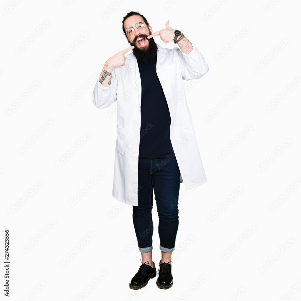 Doctor therapist man with long hair and bear wearing white coat smiling confident showing and pointing with fingers teeth and mouth. Health concept. Doctor therapist man with long hair and bear wearing white coat smiling confident showing and pointing with fingers teeth and mouth. Health concept.