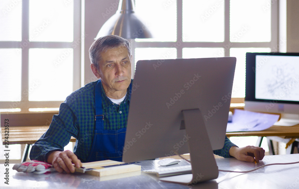 Engineer carpenter working on laptop and sketching project