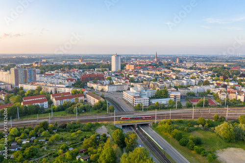 aerial view of the city of rostock, railway tracks, river warnow and power plant chimney in the background