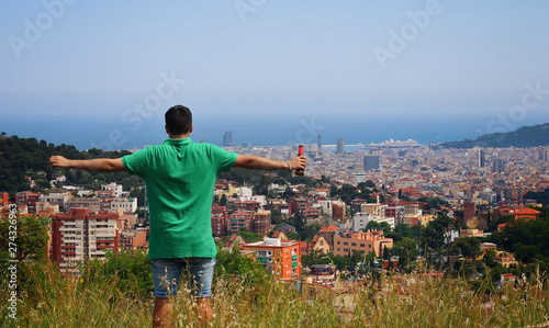 Man dressed in green raising his hands on the mountain.