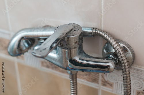 Old faucet with shower. Water tap in the bathroom.