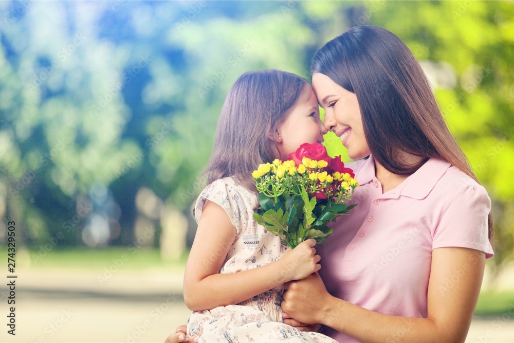 Portrait of happy mother and daughter holding flowers Portrait of happy mother and daughter holding flowers