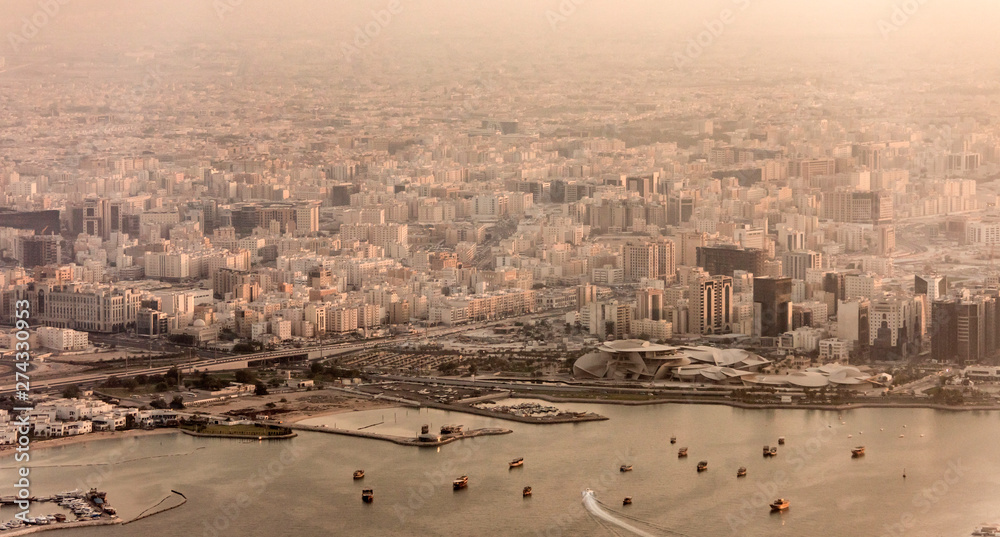 Aerial view of city of Doha, Qatar at sunset with dusty haze.
